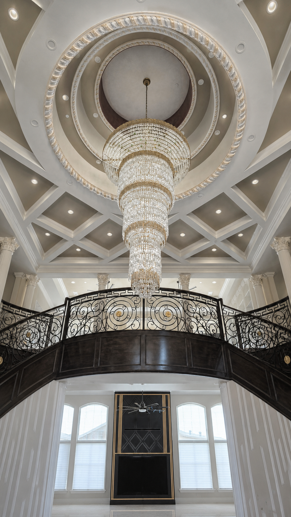 Grand custom home chandelier above a bright interior entry