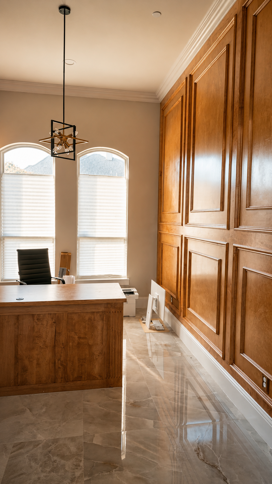 Custom home office with built-in desk and tall windows