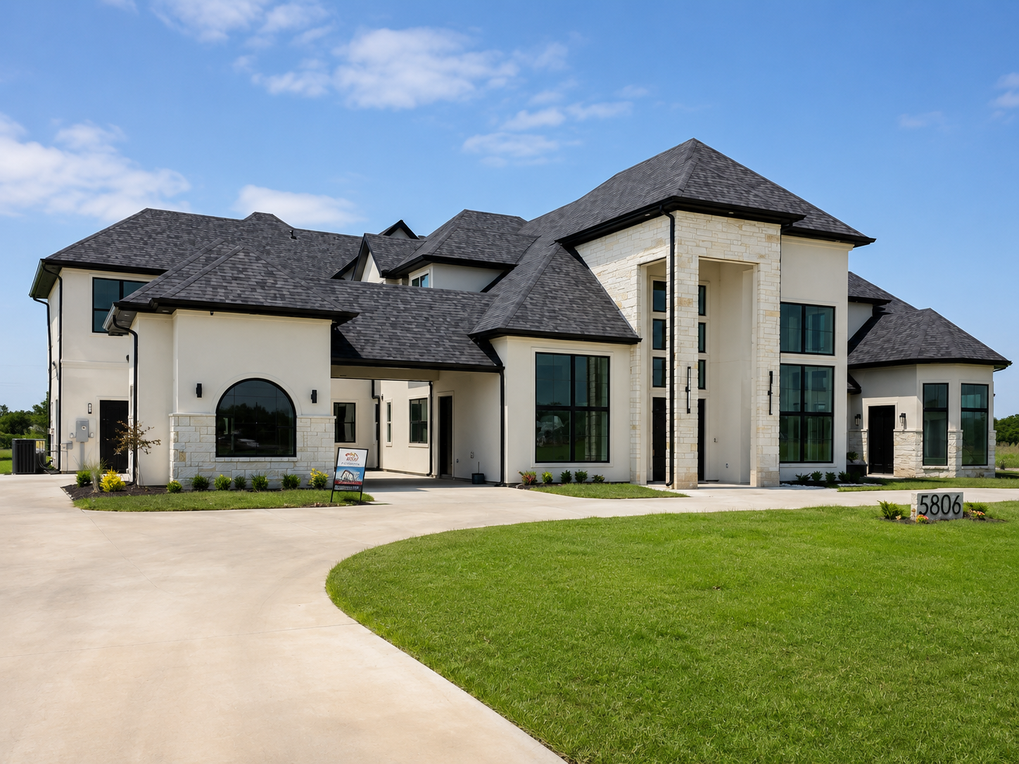 Modern transitional custom estate with stone entry tower, black windows, and broad driveway