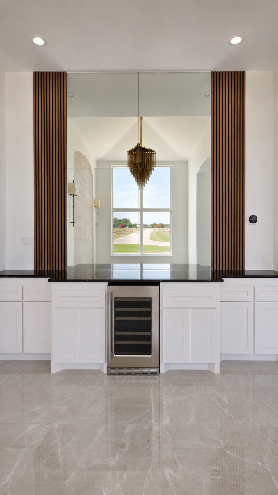 Kitchen wall with oven, cabinetry, and tall window