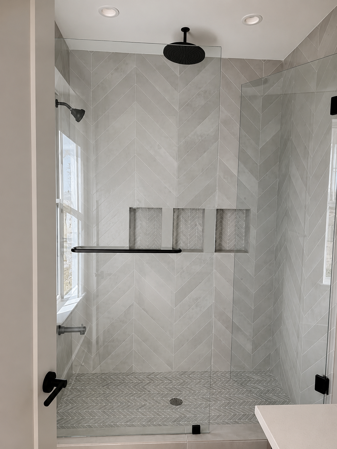 Standing shower with tile walls and glass enclosure