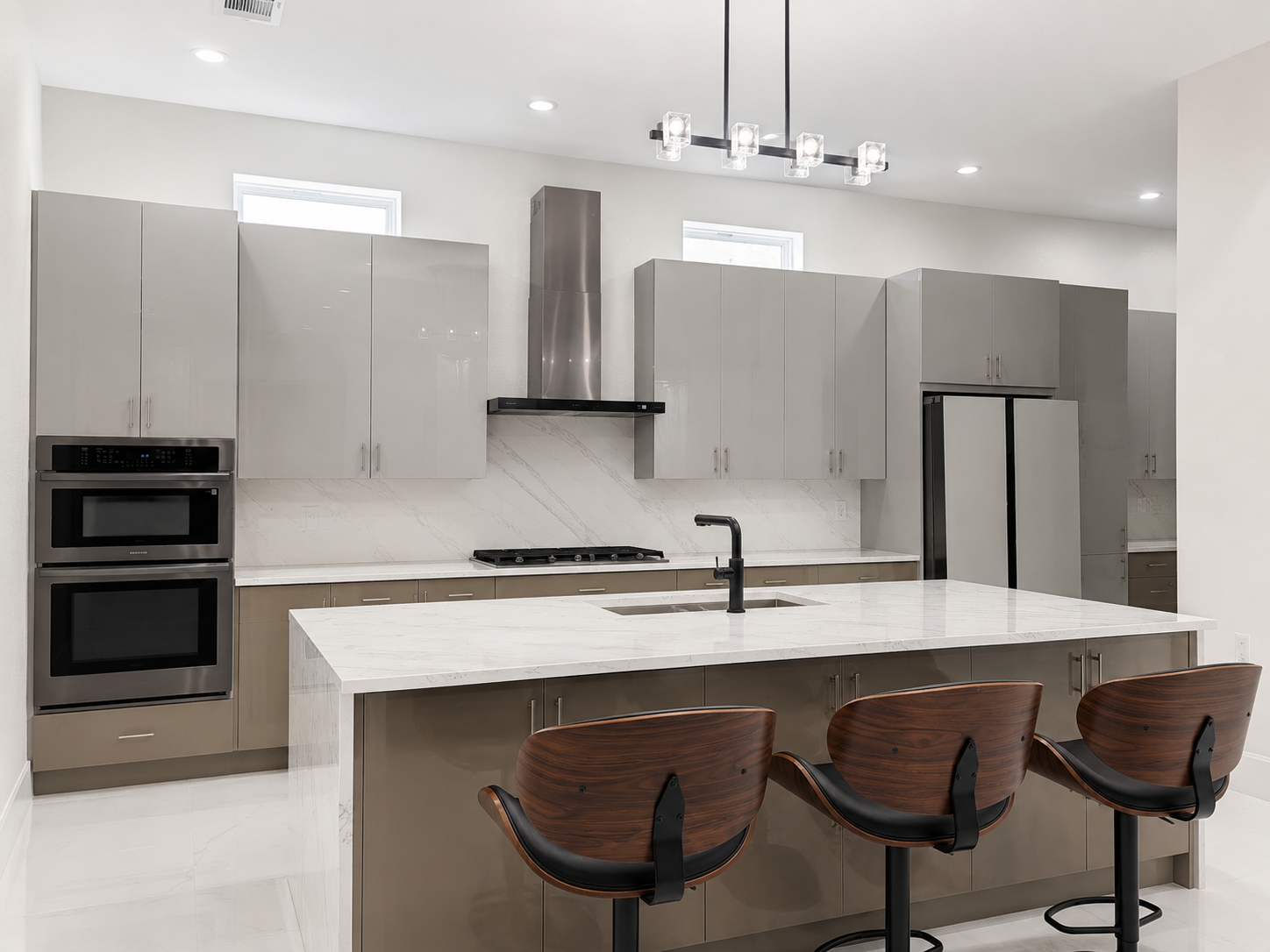 Custom kitchen with large white island, warm gray cabinetry, and wood counter stools