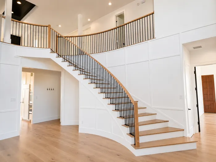 Finished custom home staircase with clean railings and bright interior finishes